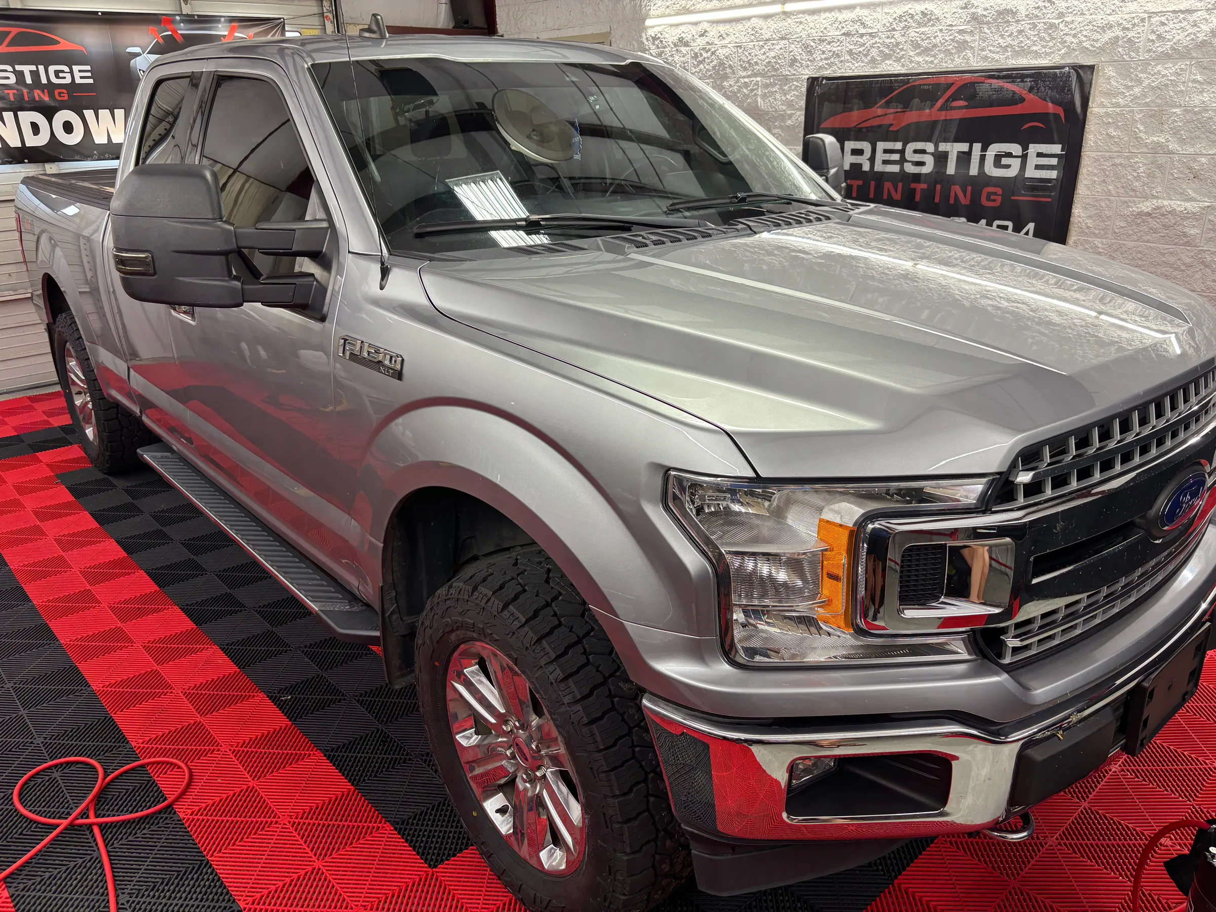 Silver Ford F-150 pickup truck with tinted windows on display at Prestige Tinting in Conway, SC.