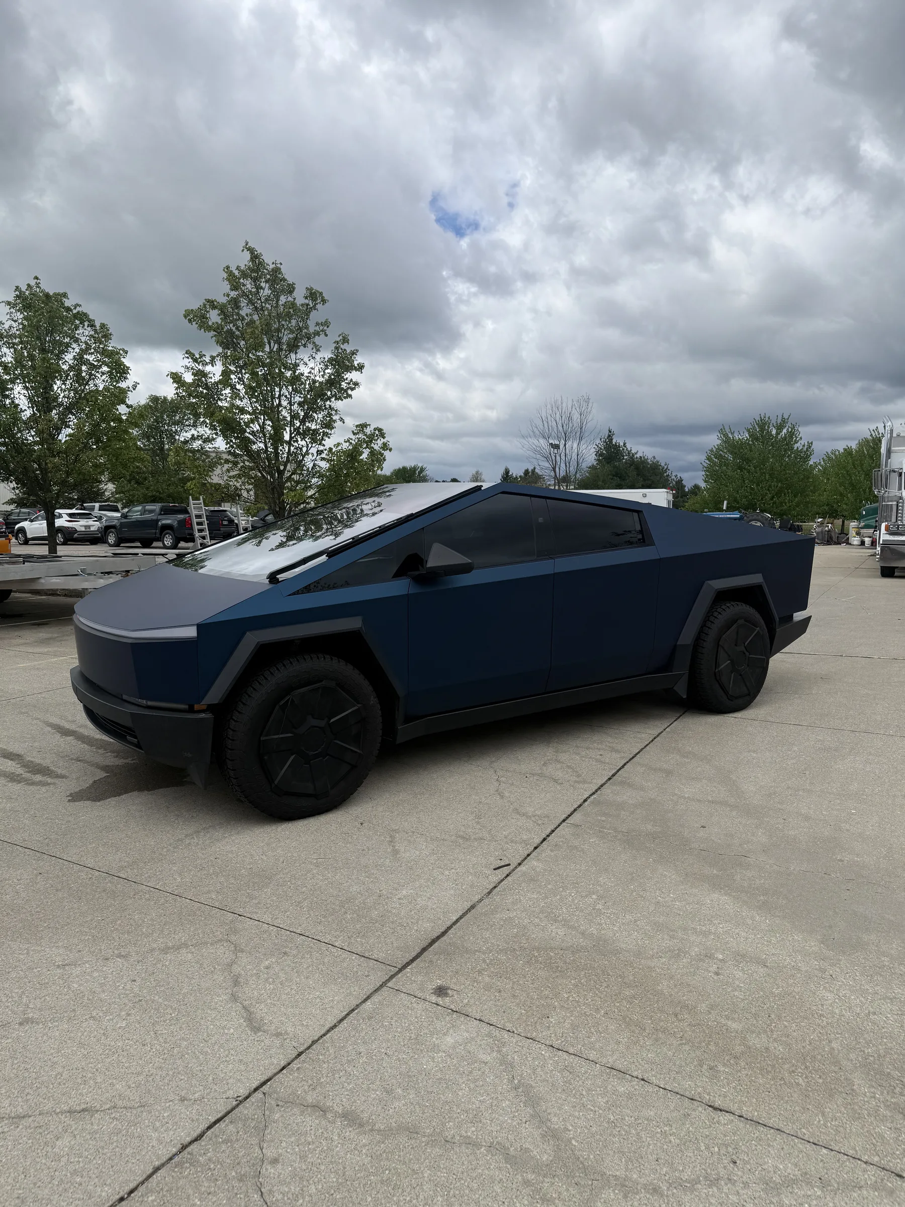 A black Toyota Prius with window tint parked in a commercial lot at sunset.