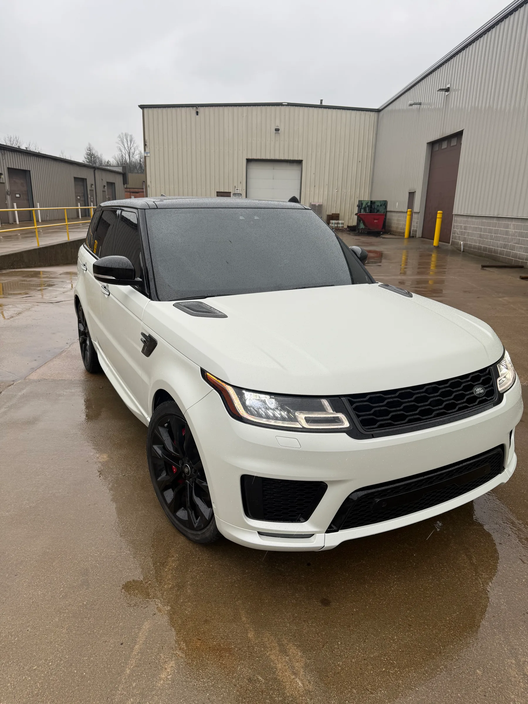 White Range Rover Sport with tinted windows parked at a commercial facility in Berea.