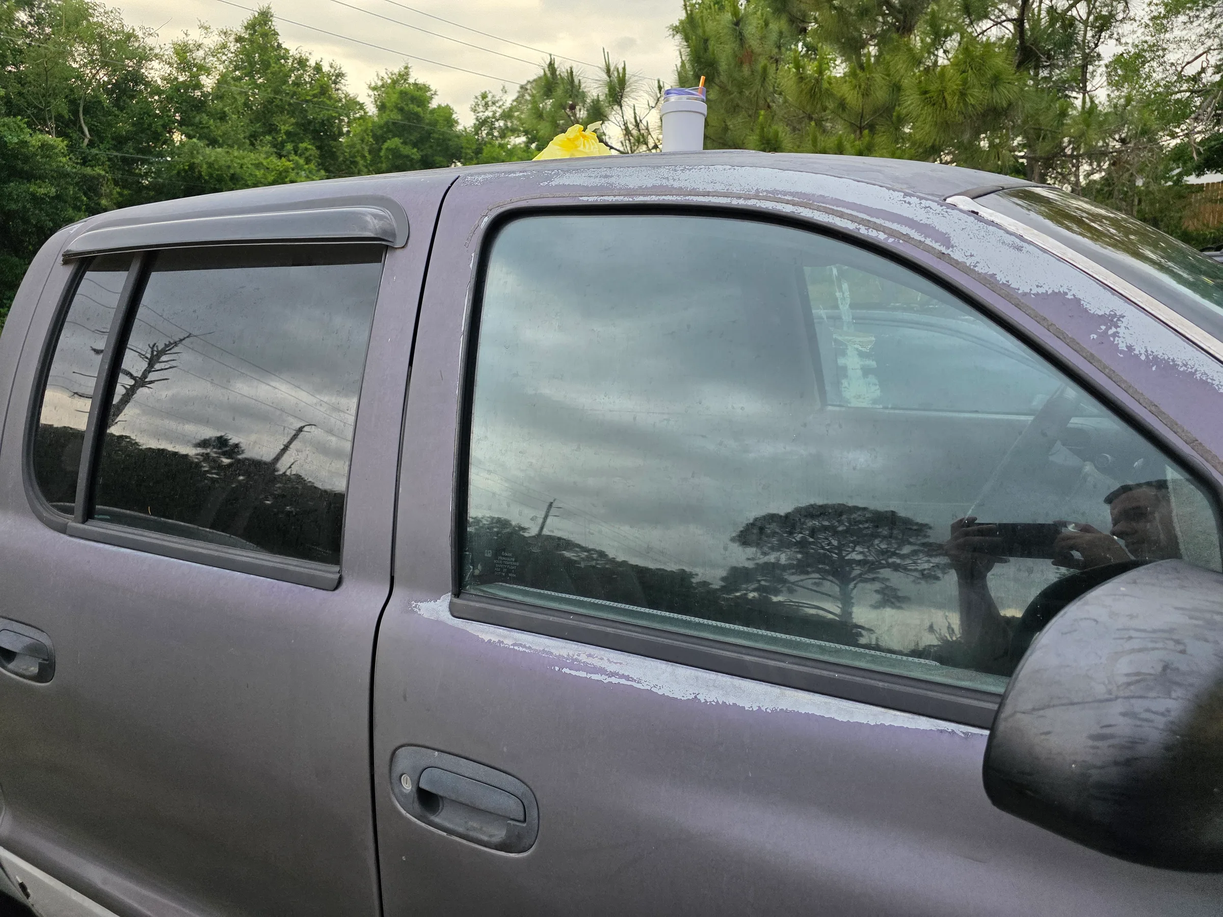 A silver pickup truck with professionally installed window tint on the side and rear windows, showing the dark tint film applied to the glass.