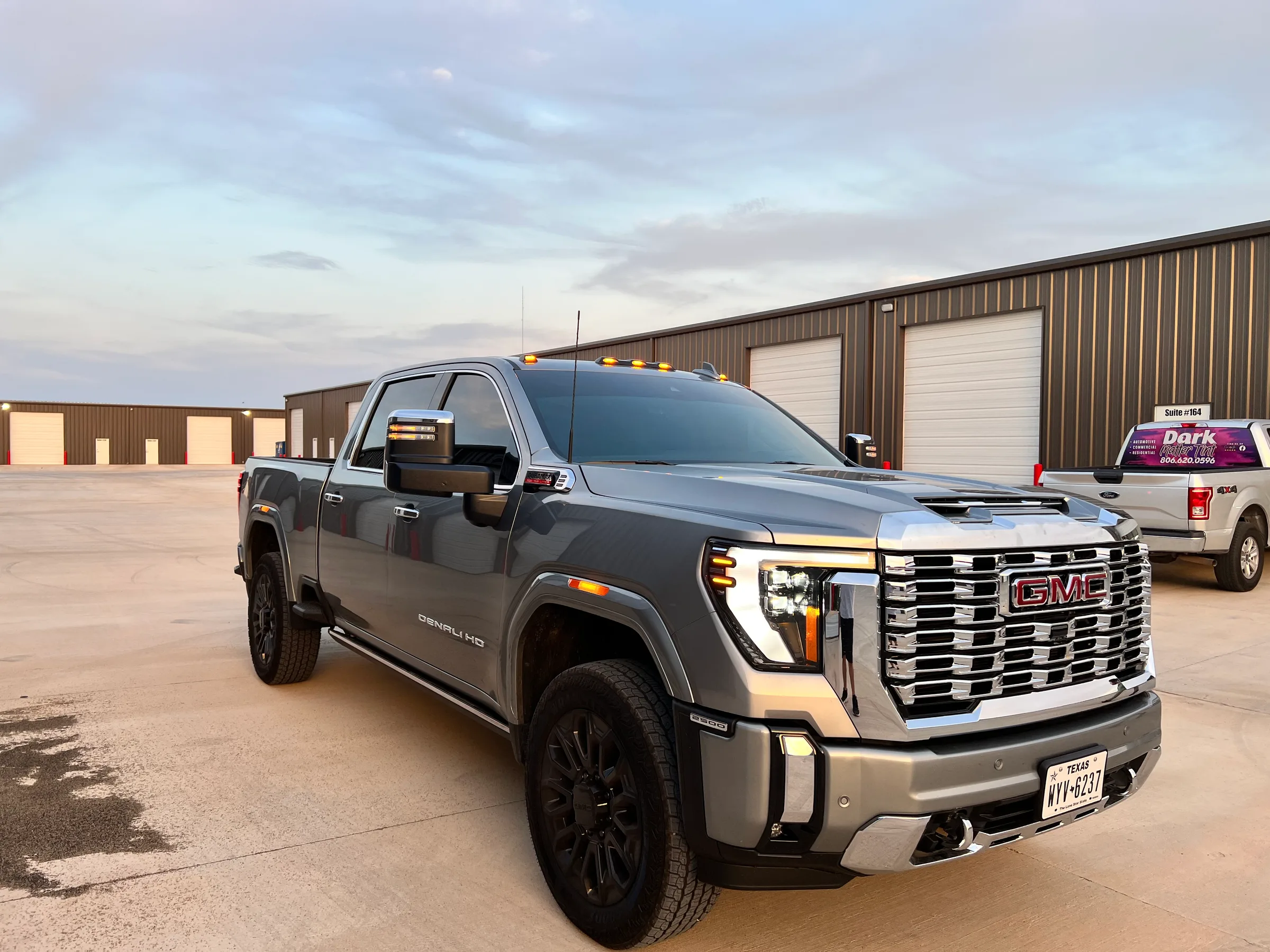 Gray GMC Denali pickup truck with tinted windows parked in front of a commercial building in Lubbock, Texas.