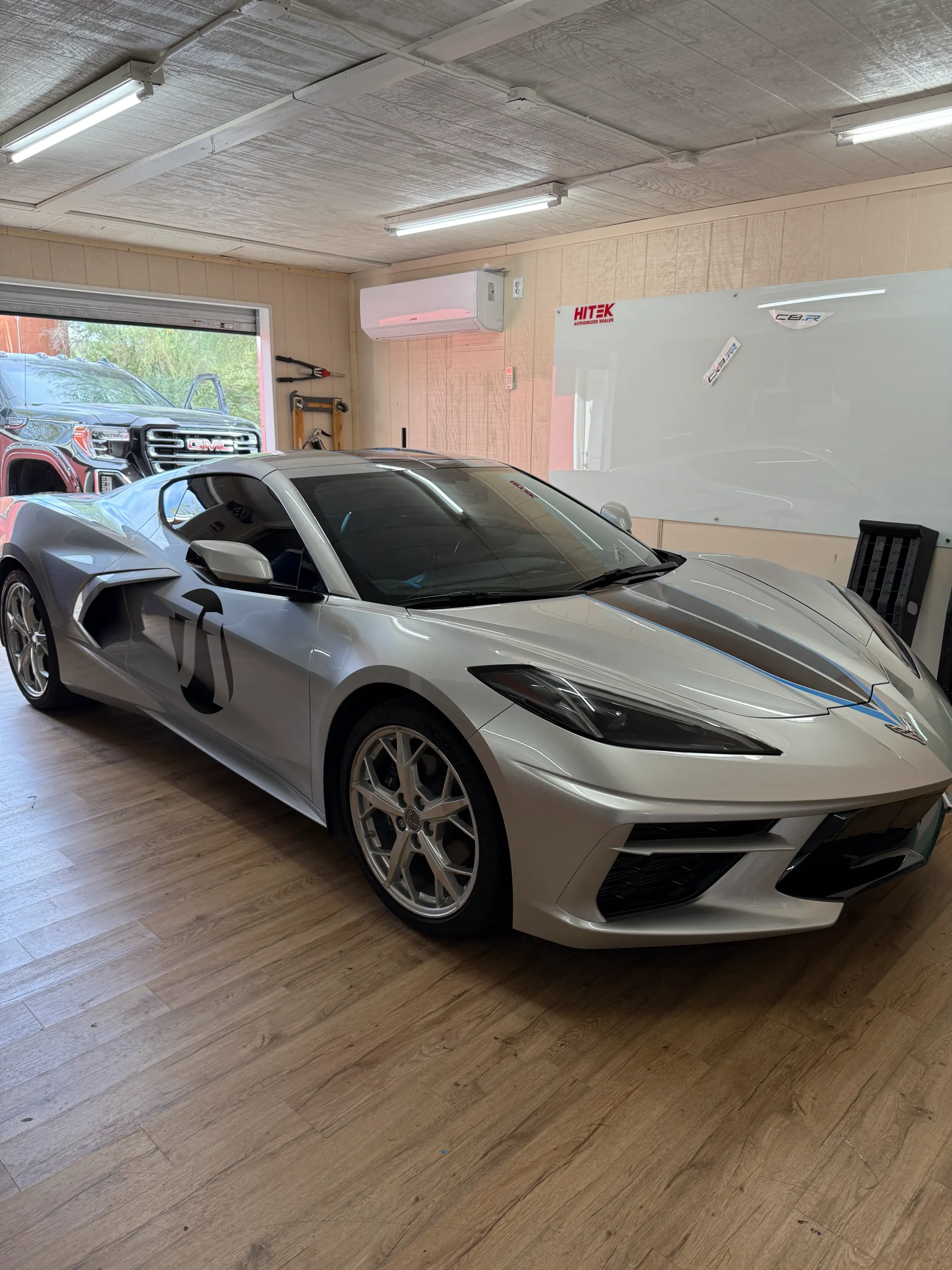 Silver Chevrolet Corvette C8 with tinted windows in a professional installation bay at Desert Shade Tinting in Cave Creek, Arizona.