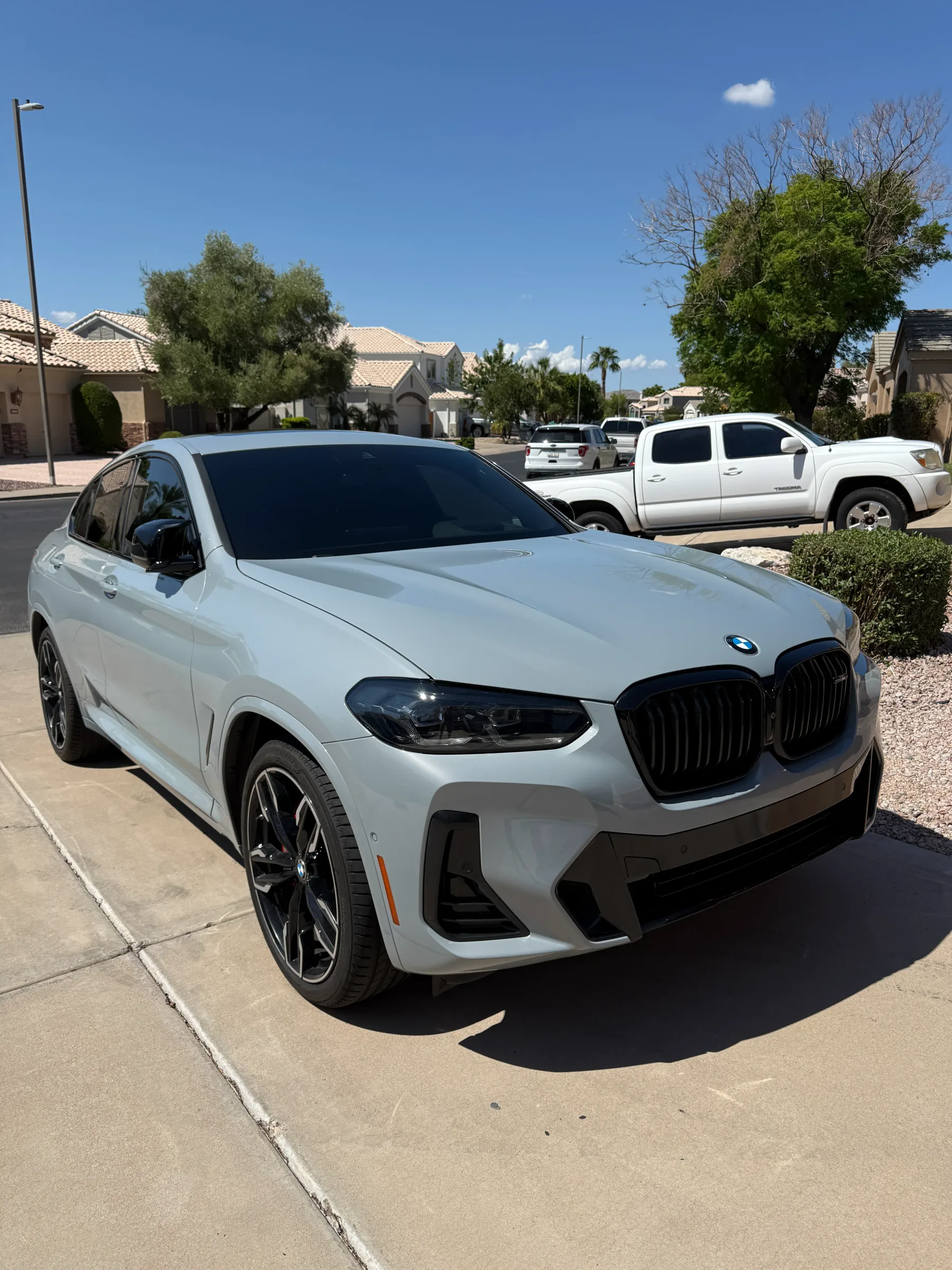White BMW X6 with dark window tint applied, parked in a residential driveway in Cave Creek.