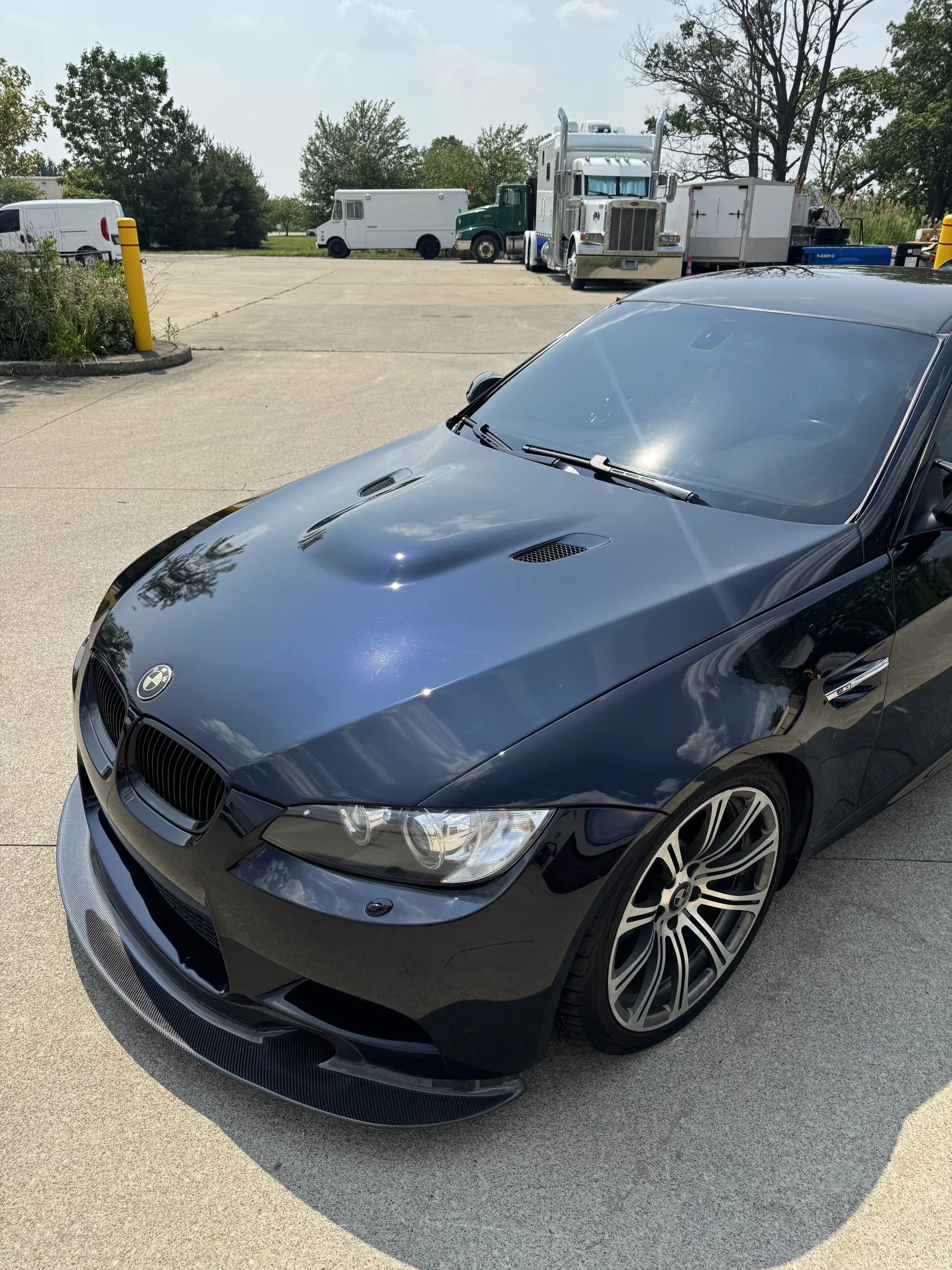 A black BMW coupe with a glossy ceramic-coated finish parked in a lot.