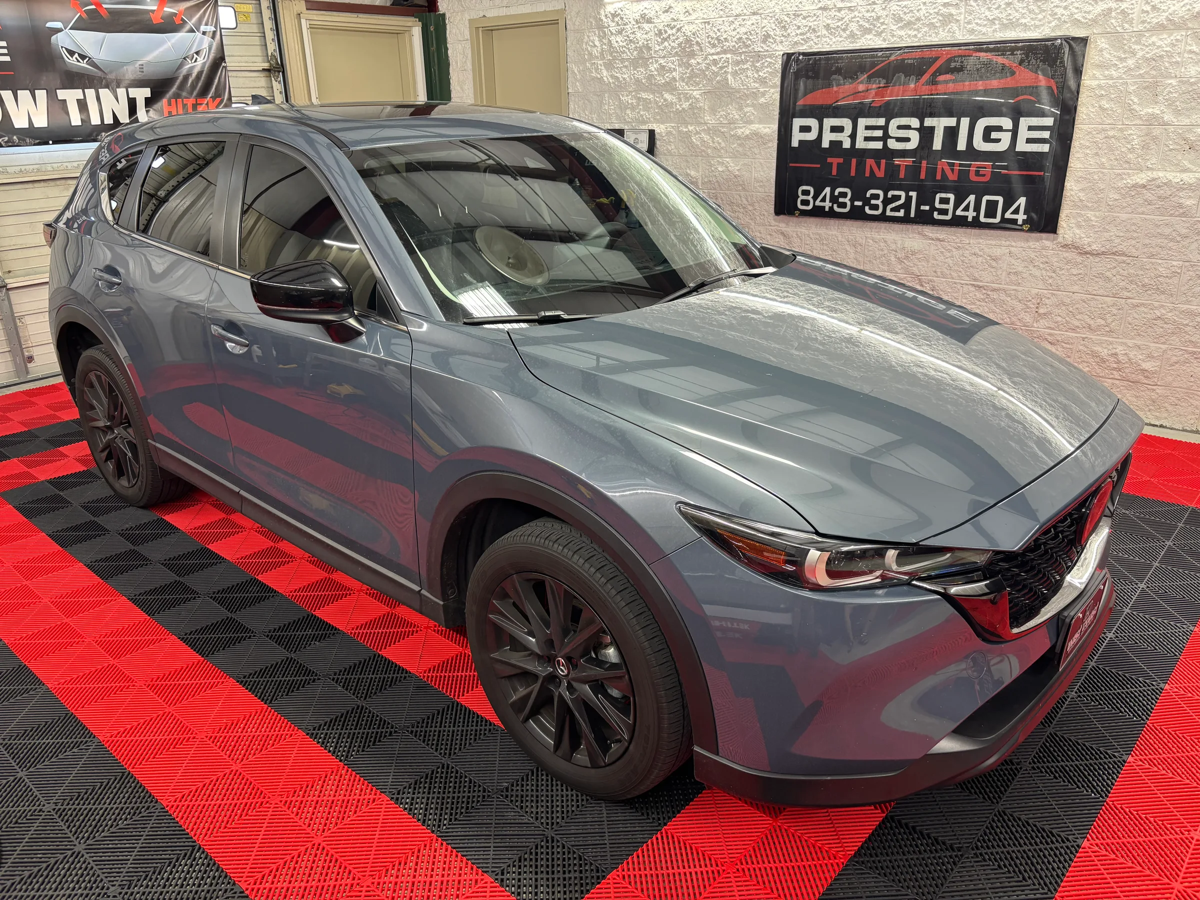 Gray Mazda CX-5 SUV with dark window tint displayed at Prestige Tinting showroom in Conway, SC.
