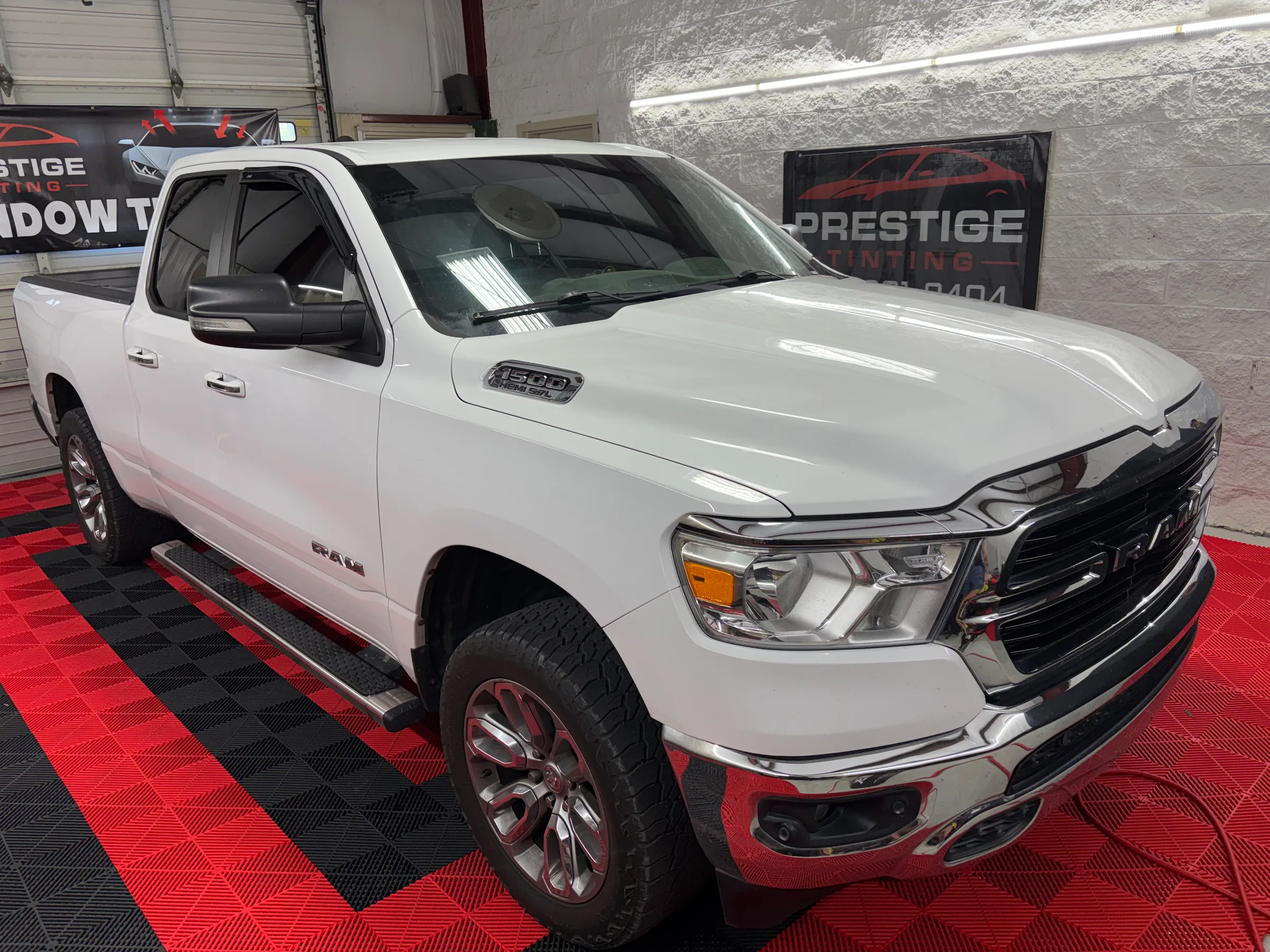 White Ram 1500 pickup truck with tinted windows displayed at Prestige Tinting shop in Conway.