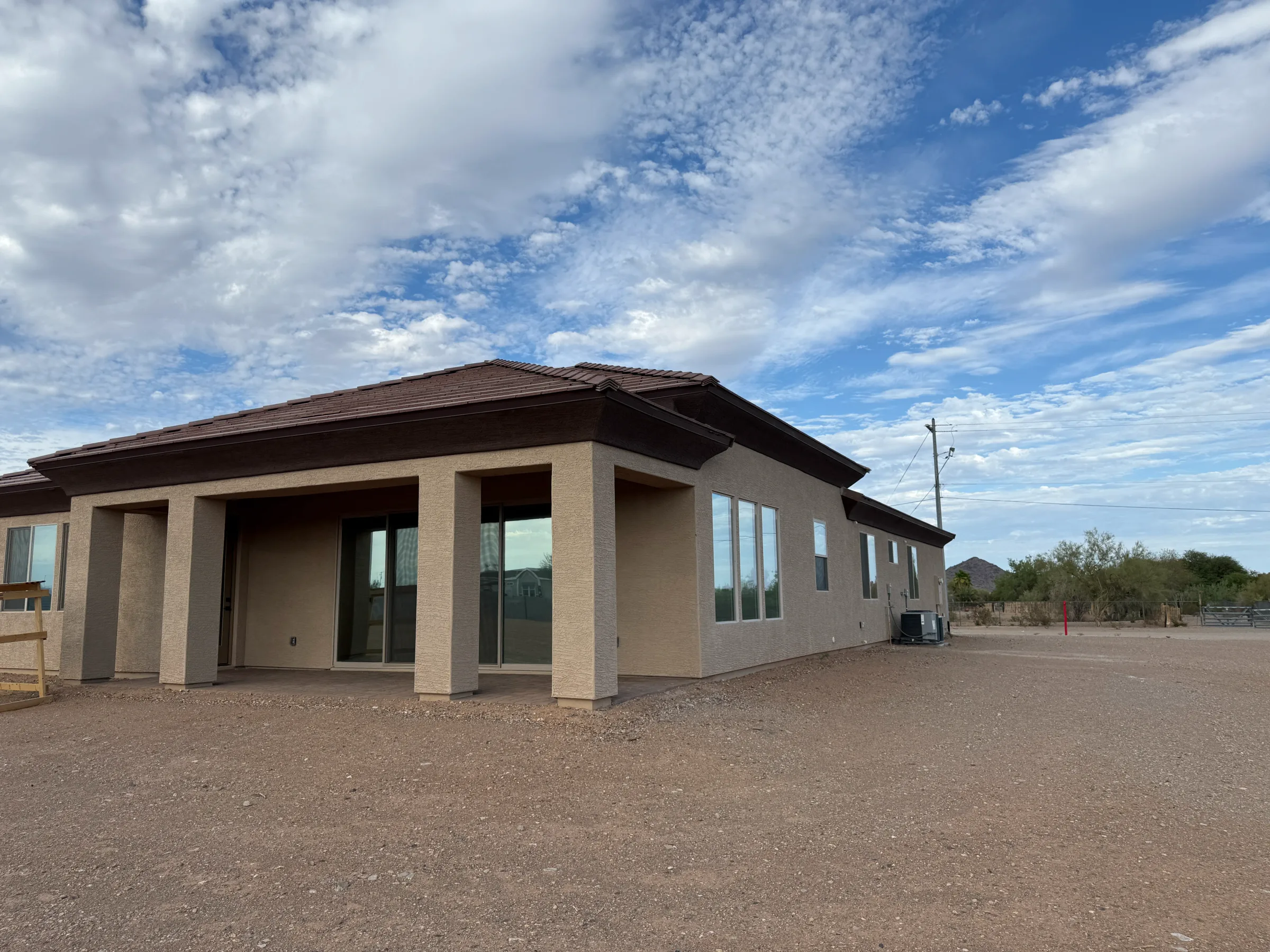 Modern brick commercial building with large tinted windows and covered entryway in a desert setting near Cave Creek, Arizona.