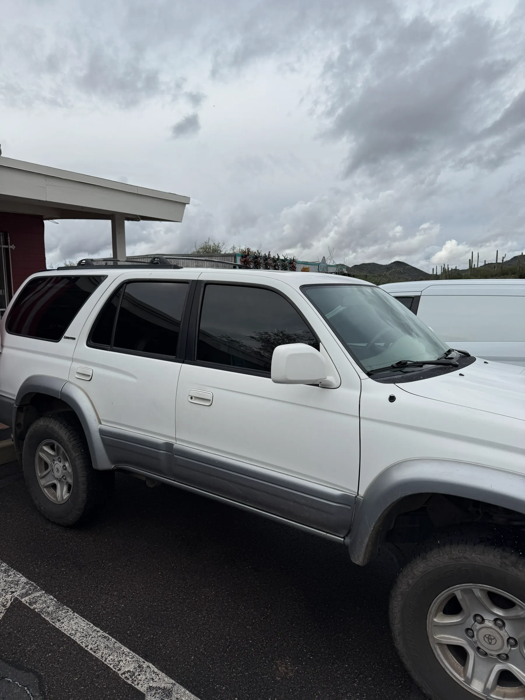 White Toyota 4Runner with dark window tint applied to all side and rear windows, parked at a tinting shop in Cave Creek.