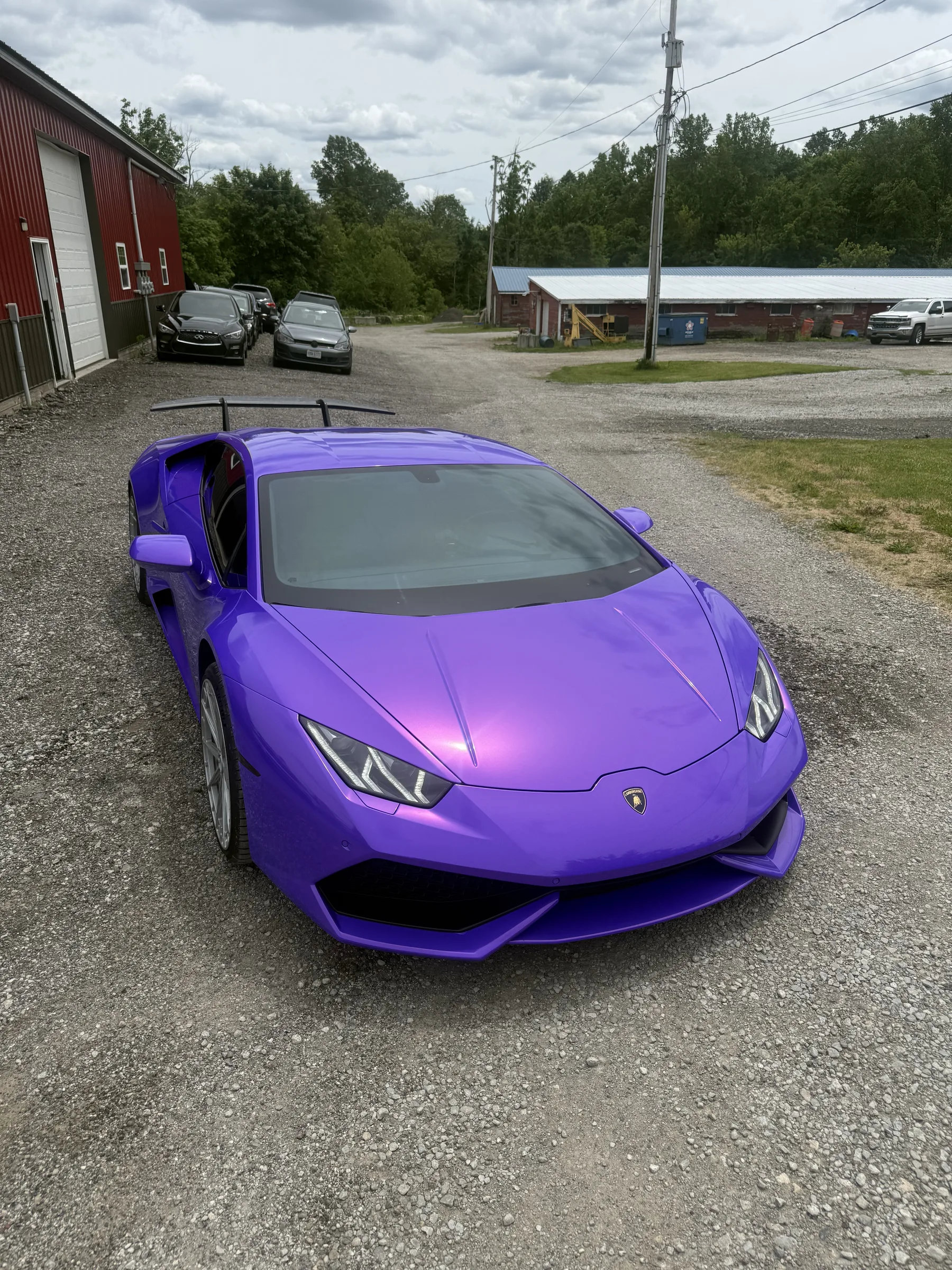 A bright purple Lamborghini Huracán with tinted windows parked at a service facility in Berea, Ohio.