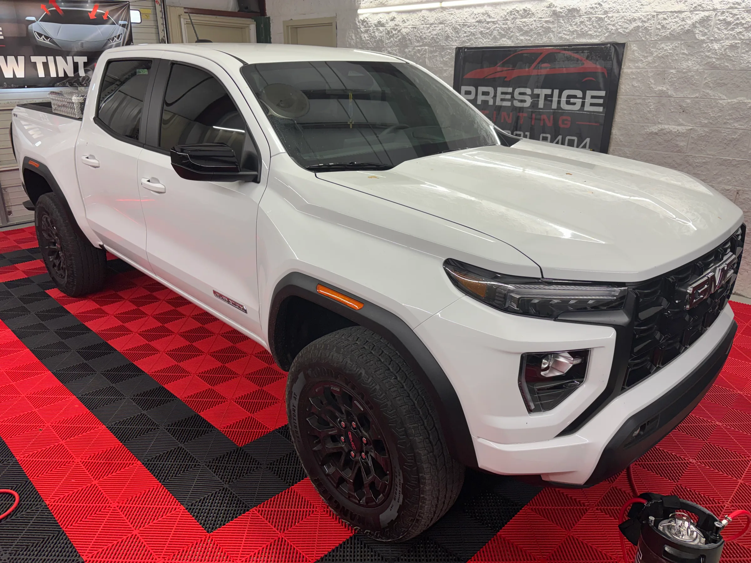 White Chevrolet Colorado pickup truck with dark window tint displayed at Prestige Tinting in Conway.