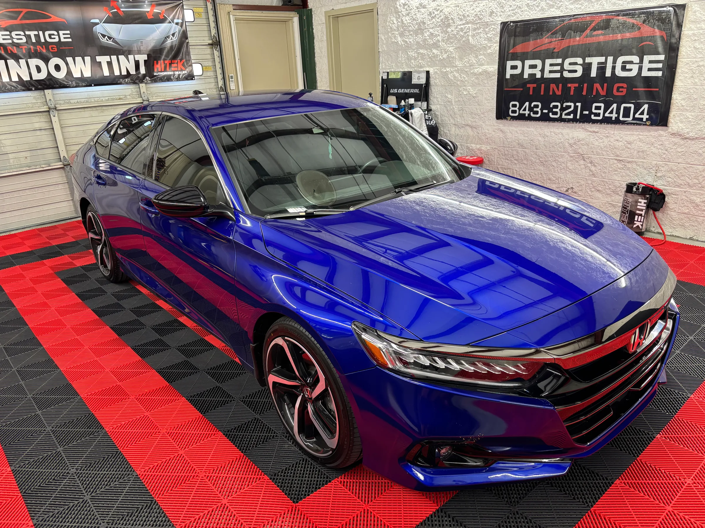 A bright blue Honda Civic with window tint applied, displayed in the Prestige Tinting showroom in Conway, SC.