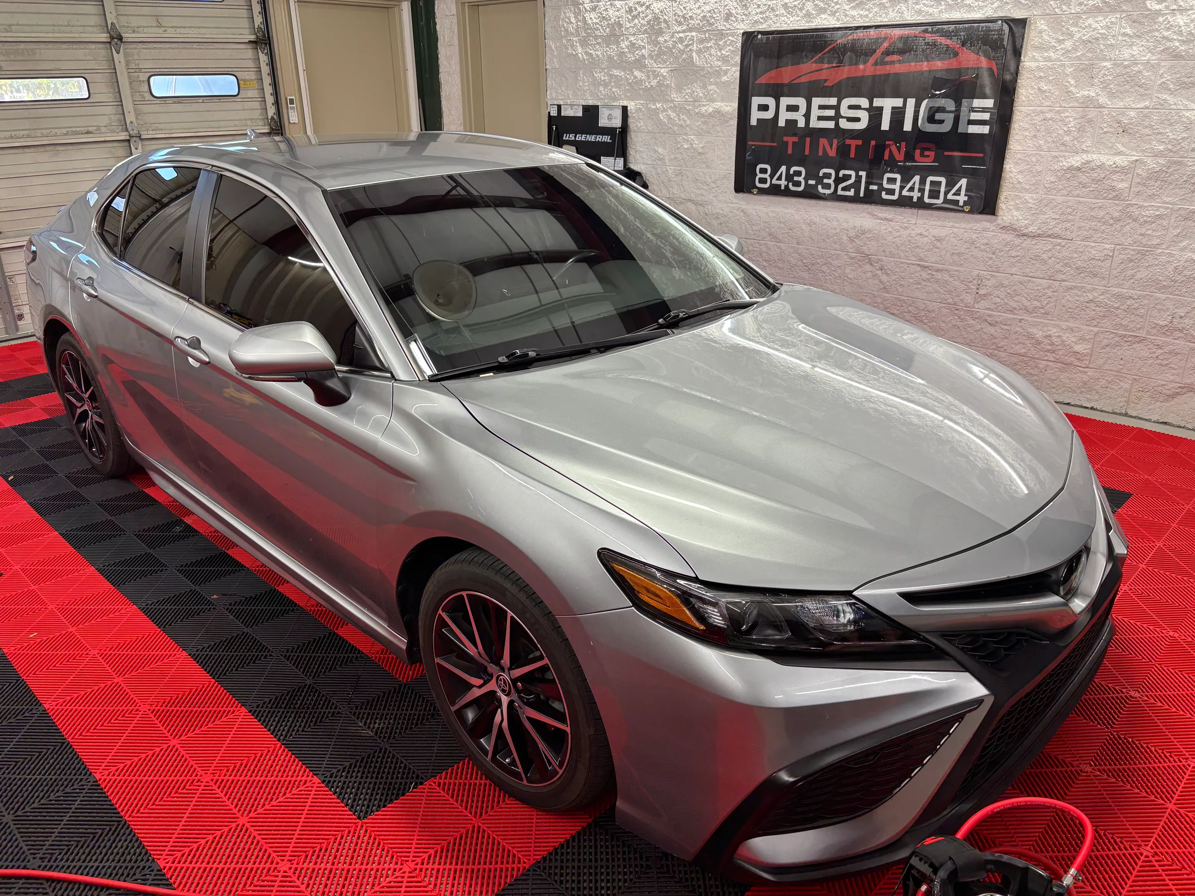 Silver Toyota Camry with dark window tint displayed in the Prestige Tinting shop in Conway, SC.